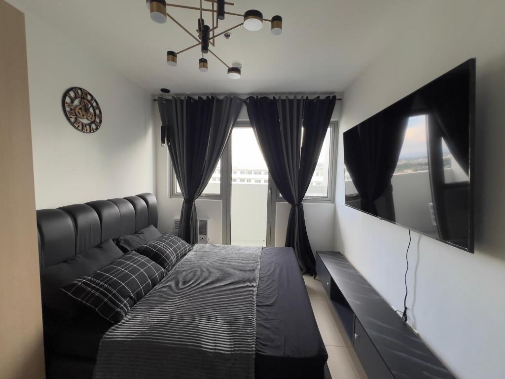 1 dormitorio con cama y ventana grande en Apartment in Batasan Hills in QC, en Manila