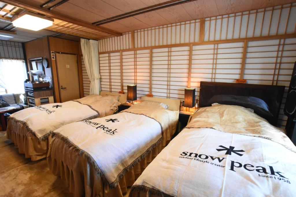 a room with three beds with snowstals on them at Natural Mind Tour guest house - Vacation STAY 22268v in Sado