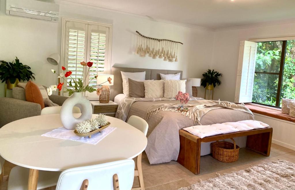 um quarto com uma cama, uma mesa e um sofá em Maleny Lake Cottages em Maleny