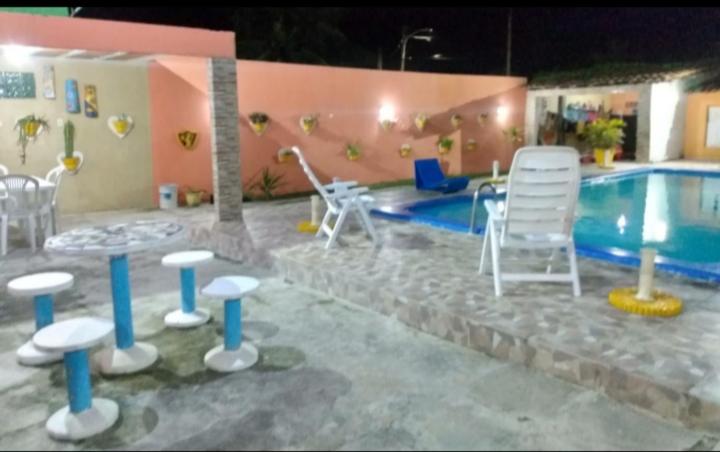 a resort with a swimming pool and chairs and a table and a swimming pool at Praia de serranbi in Porto De Galinhas