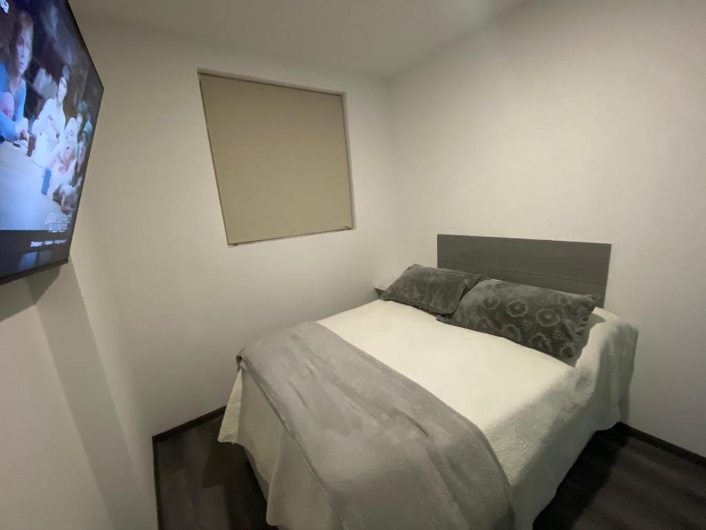 Dormitorio pequeño con cama y TV en Edificio nuevo, en Hermosillo