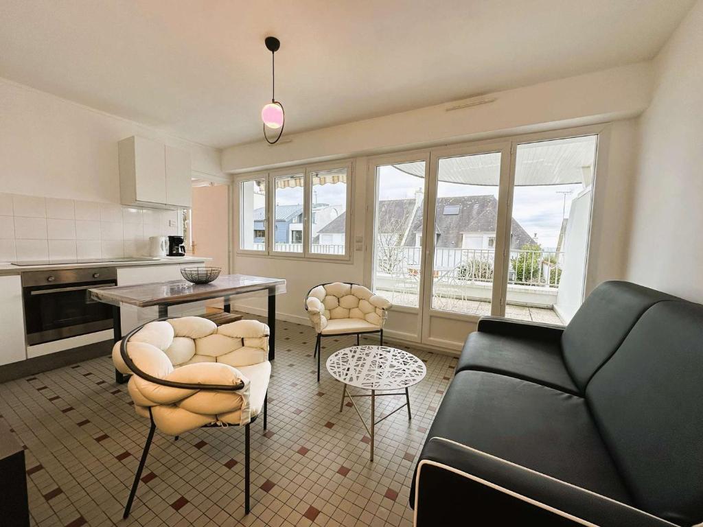 un salon avec un canapé, une table et des chaises dans l'établissement Fouesnant, 50m plage Cap Coz, app. cosy 2 pers, terrasse, parking - FR-1-481-154, à Fouesnant