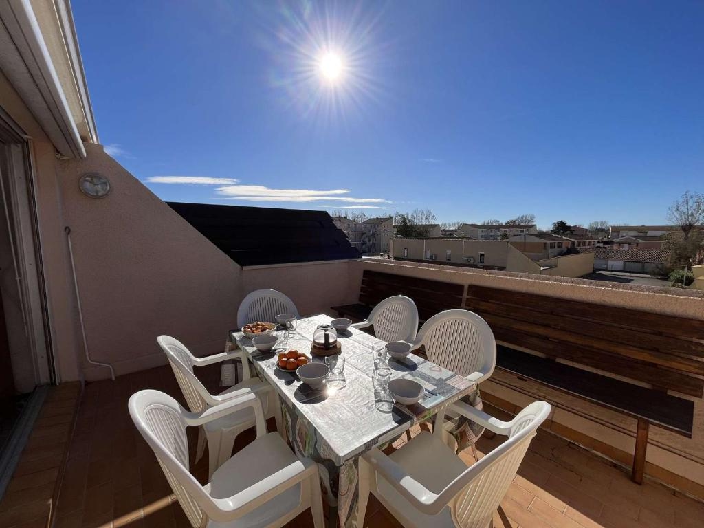 einen Tisch und Stühle auf einem Balkon mit Aussicht in der Unterkunft Appartement Marseillan-Plage, 2 pièces, 6 personnes - FR-1-387-201 in Marseillan