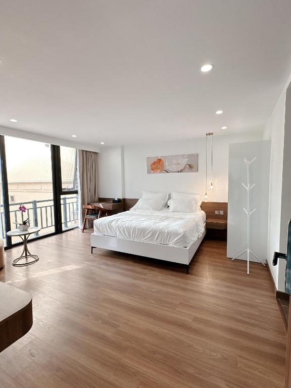 - une chambre avec un lit blanc et un balcon dans l'établissement TINH ANH HOME, à Hanoï