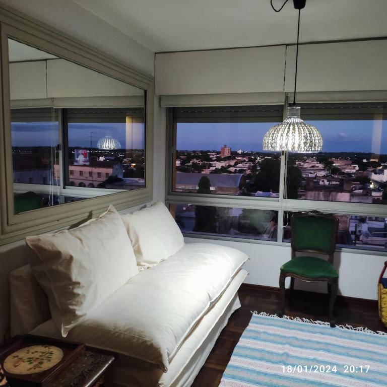 Espectacular salto centro في سالتو: غرفة معيشة مع أريكة بيضاء ونوافذ كبيرة