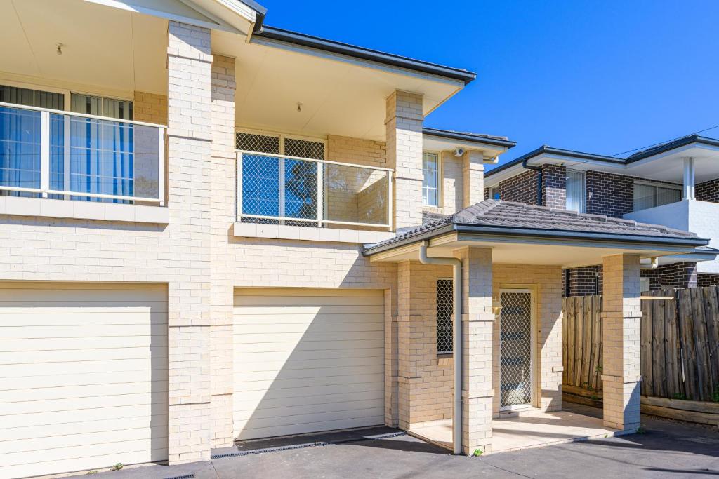 a house with two garage doors in front of it at DundasParramattatwo-level 3Br HouseWiFi&Parking in Sydney