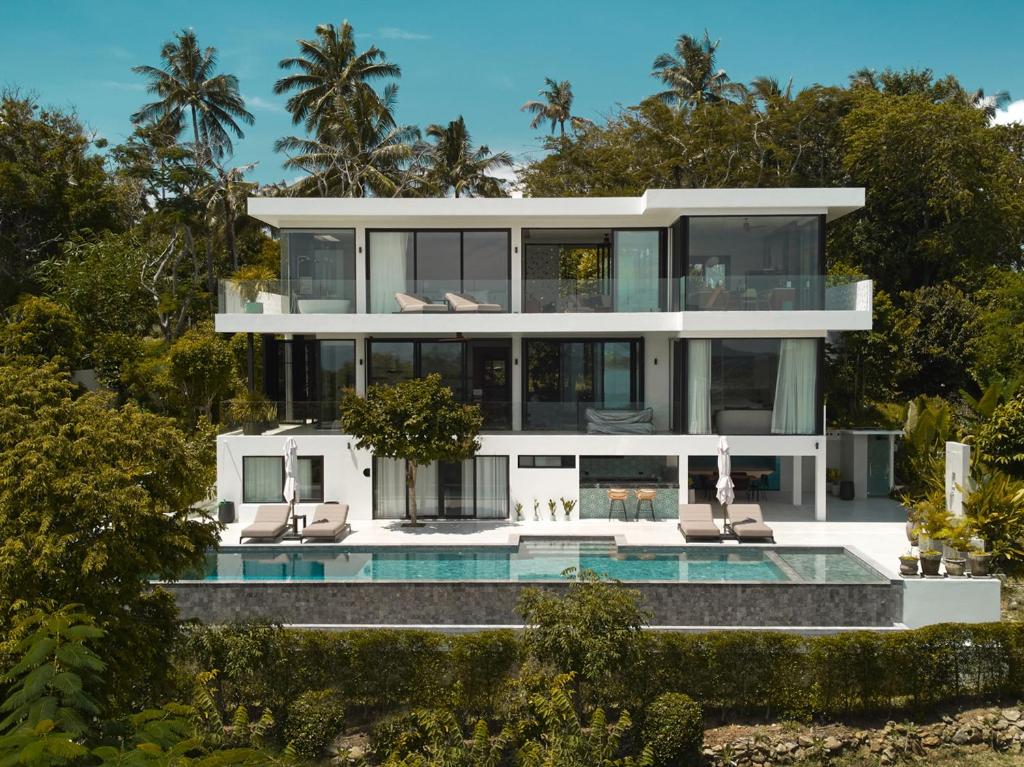 a large white house with a swimming pool at Casa Alma by Elite Havens in Nai Harn Beach
