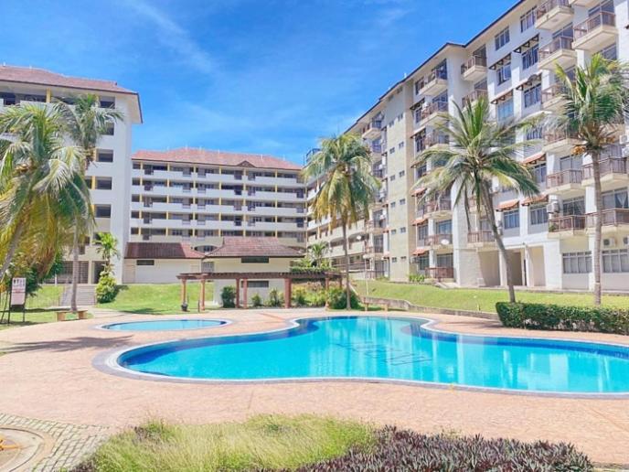 un complejo de apartamentos con piscina frente a un edificio en Sweet Homestay en Port Dickson