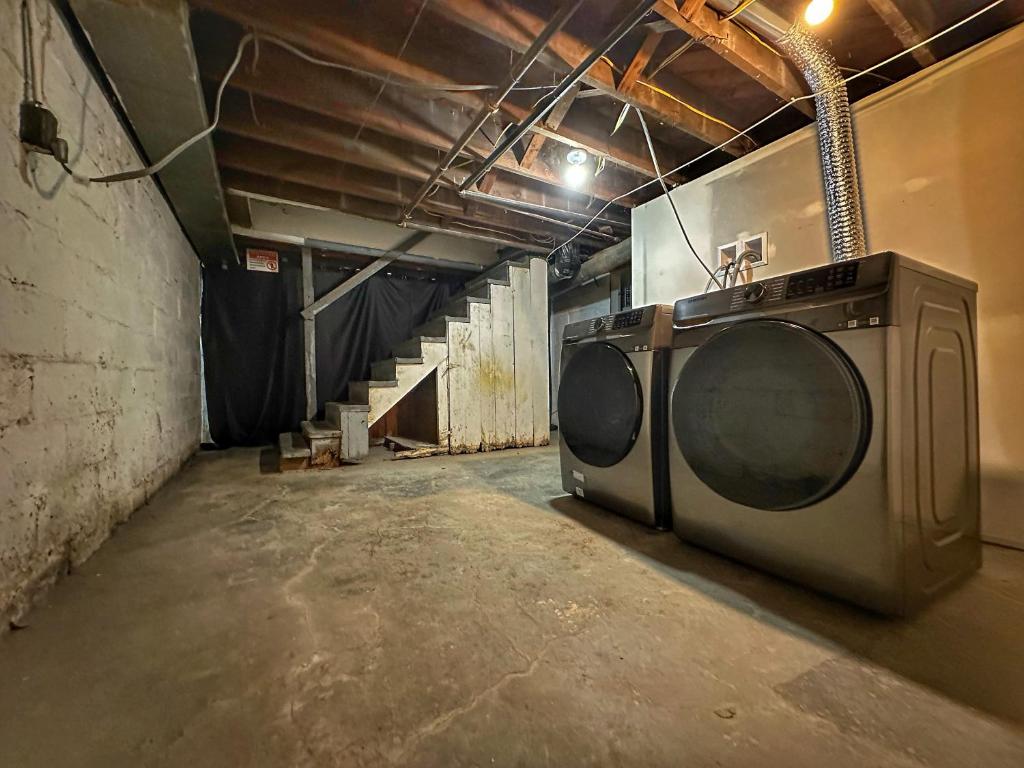 a washing machine in a room with a staircase at Modern Luxe 3BR/1BA with Bar in Columbus
