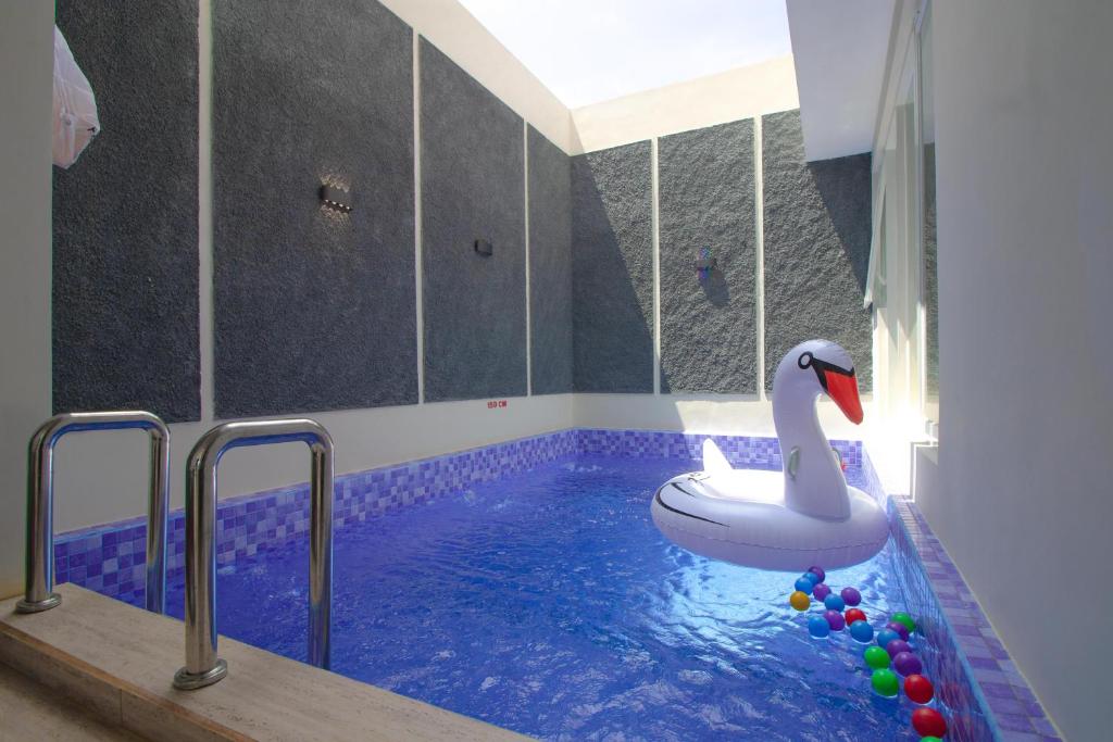 une piscine avec un flotteur en forme de cygne dans une salle de bain dans l'établissement Villa 17 Celcius Private Pool and Rooftop, à Tlekung
