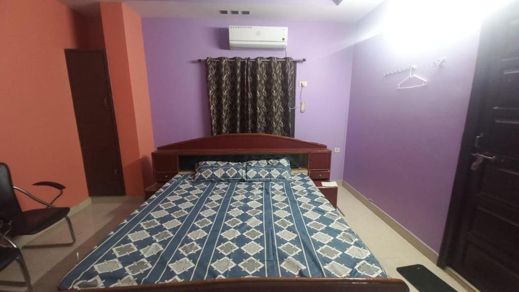 uma cama num quarto com paredes roxas em HARI HARAN em Nellore