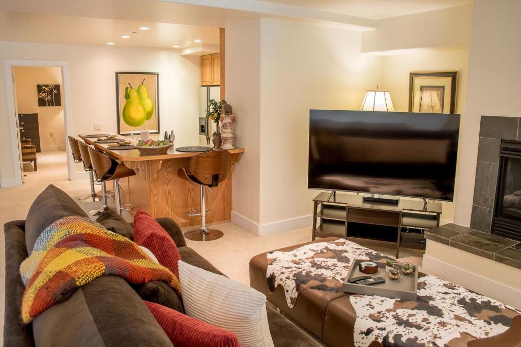 sala de estar con TV de pantalla plana grande en Thunder Springs A26 - High-End Condo with Zenergy Pool & Private Garage en Ketchum