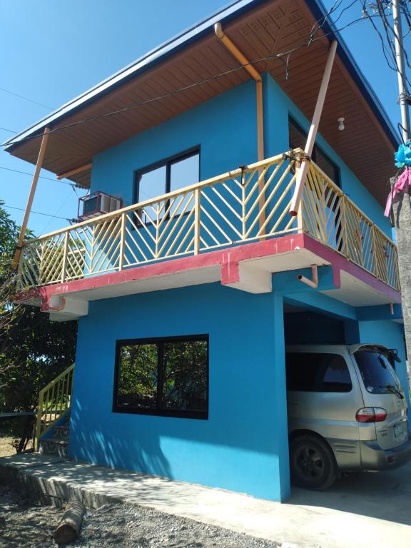 a house with a balcony and a car parked in front at Angel's Homestay 