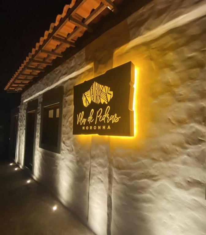 a sign for a restaurant on the side of a building at Pousada Vila de Pedras Noronha in Fernando de Noronha