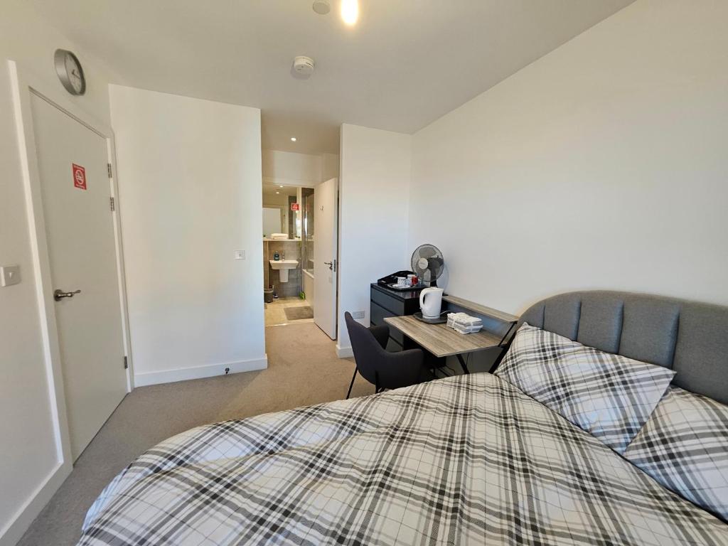 a bedroom with a bed and a desk and a room at Stylish Ensuite Double-Bed with Desk in Barking