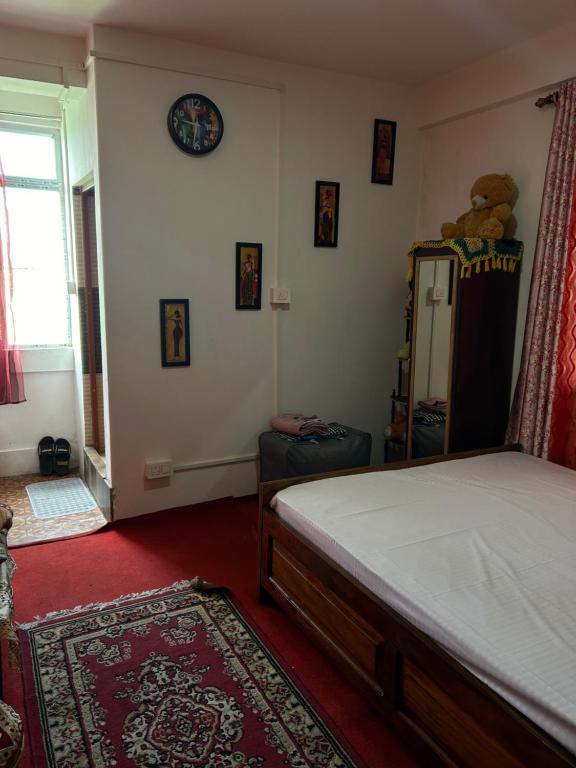 um quarto com uma cama, um espelho e uma janela em Kunsang Homestay em Ghum