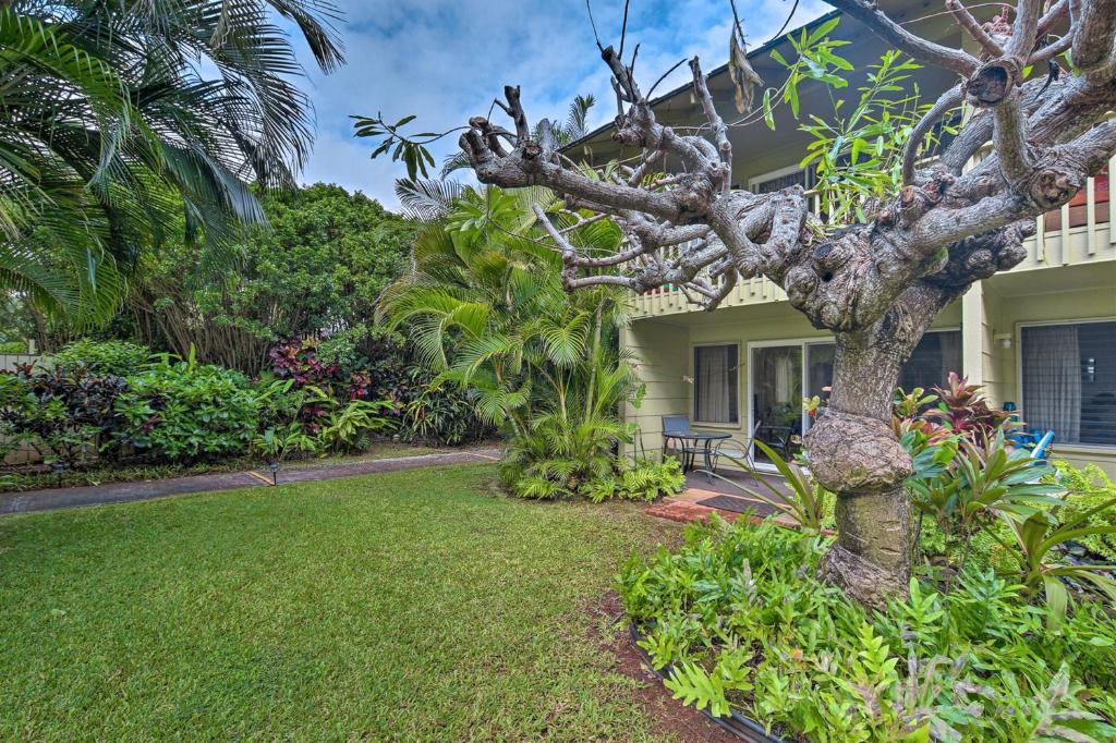 a house with a tree in front of a yard at Kapa`a Sands 18 in Kapaa