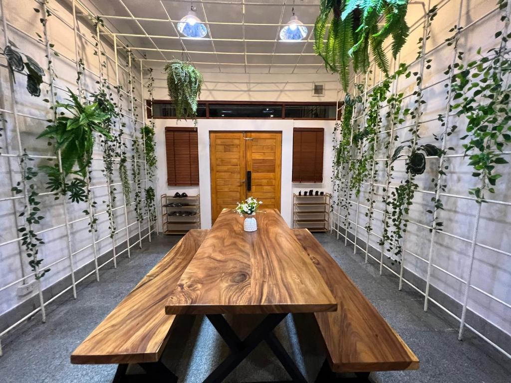 a wooden table in a room with plants on the walls at 4 Bedroom House with Beautiful Rooftop near BTS Ekkamai in Bangkok