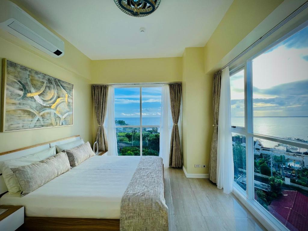 a bedroom with a bed and a large window at Relaxing 1BR Suite in La Mirada in Mactan