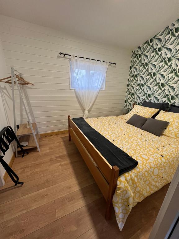 een slaapkamer met een bed en een raam bij Les gîtes de la bergerie in Meximieux