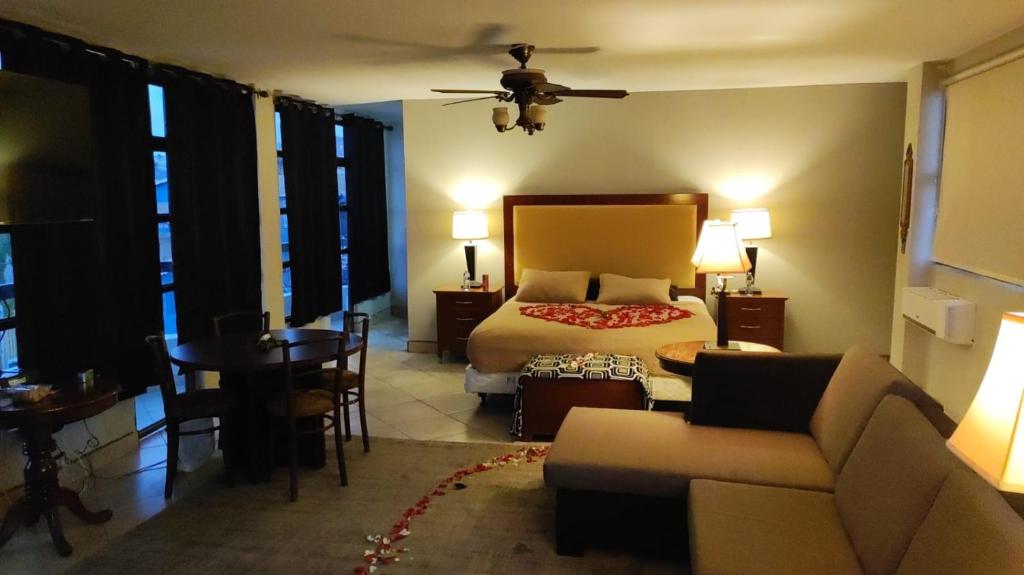 a bedroom with a bed and a couch and a table at Penthouse TJ in Tijuana