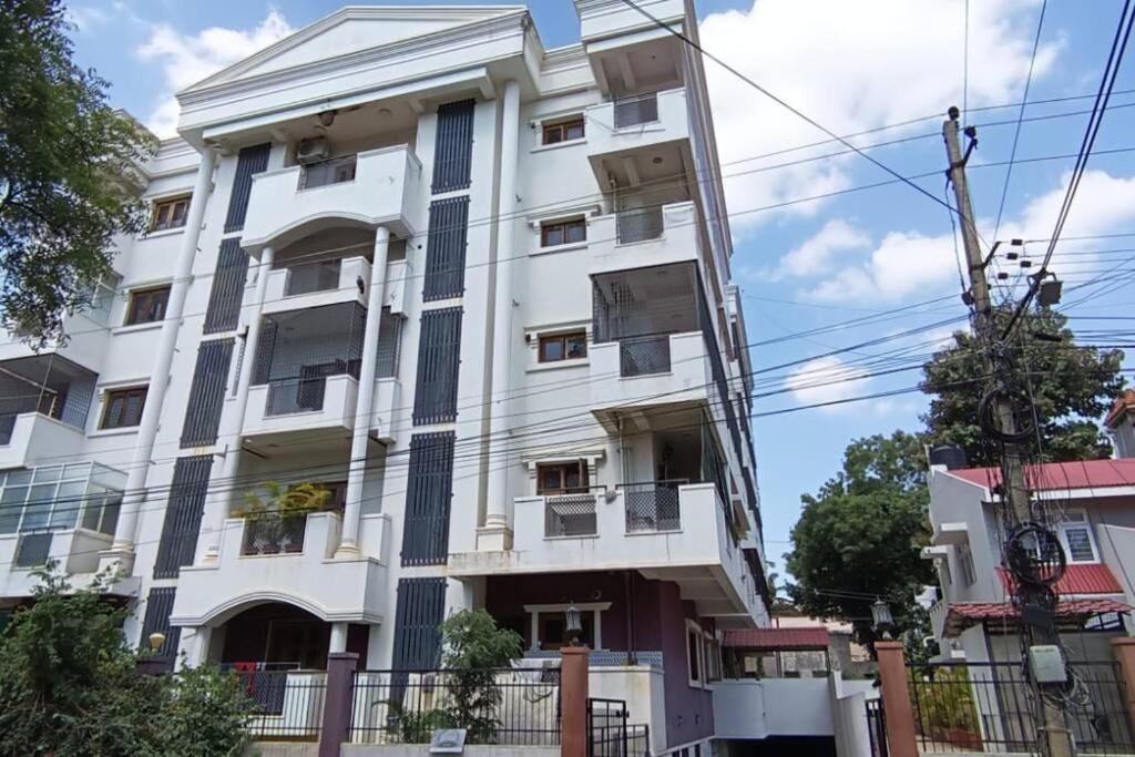 a white building with a fence in front of it at 4BHK Luxury Apartment at VV Mohalla/Mysore by Revkeys in Mysore