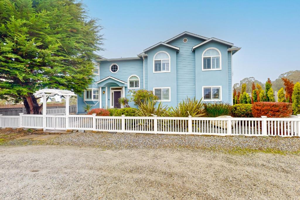 a blue house with a white picket fence at Coastal Bliss in Half Moon Bay