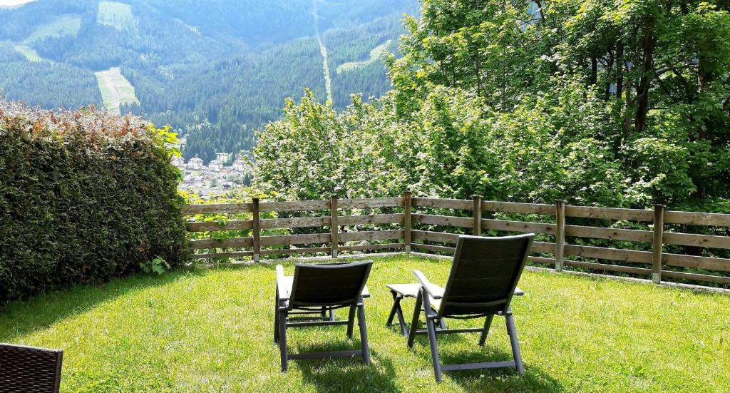 zwei Stühle im Gras vor einem Zaun in der Unterkunft Wohnung in Bach mit Terrasse und Garten in Bad Kleinkirchheim