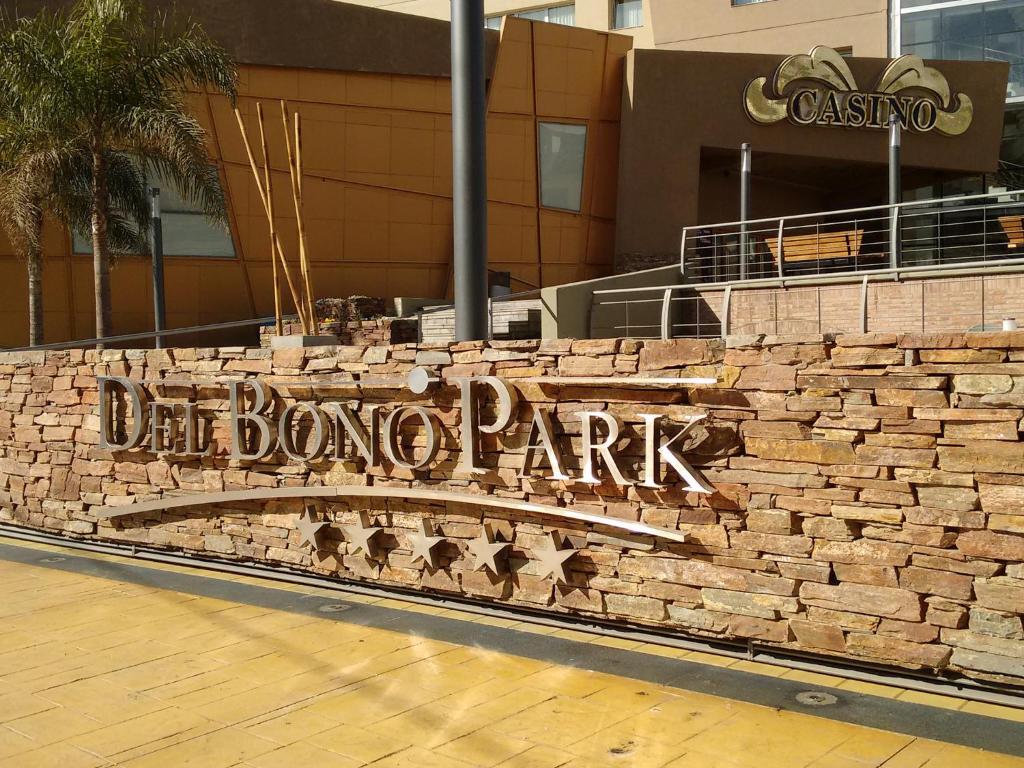 una pared de piedra con una señal frente a un edificio en Hotel Del Bono Park en San Juan