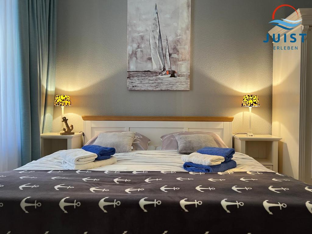 Un dormitorio con una cama con toallas azules. en Pension Marie Luise 251 - Zimmer Herzmuschel en Juist