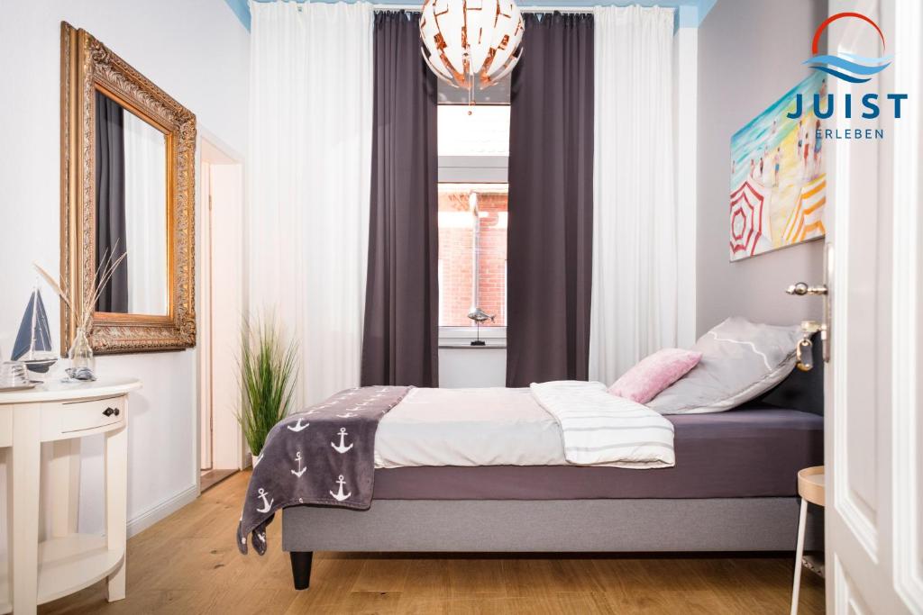 een slaapkamer met een bed en een raam bij Pension Marie Luise 254 - Zimmer Jacobsmuschel in Juist