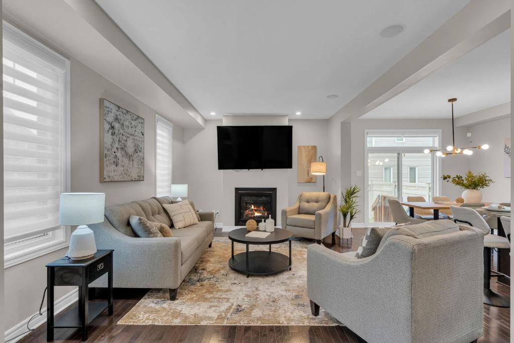 a living room with two couches and a fireplace at Luxurious and Beautiful House in Ottawa