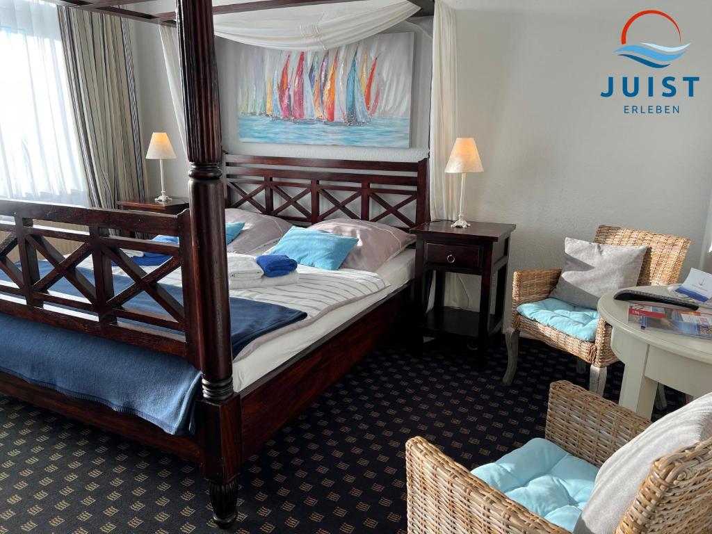 a bedroom with a canopy bed and a table and chairs at Pension Marie Luise 255 - Zimmer Kammmuschel in Juist