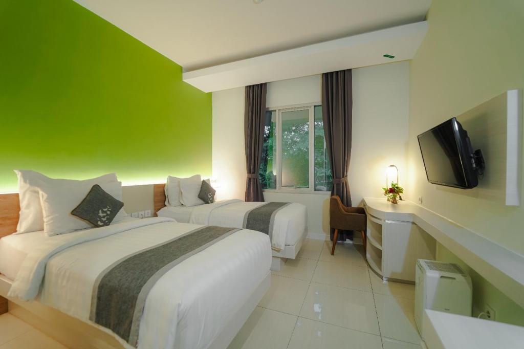 Postel nebo postele na pokoji v ubytování Patra Bandung Hotel