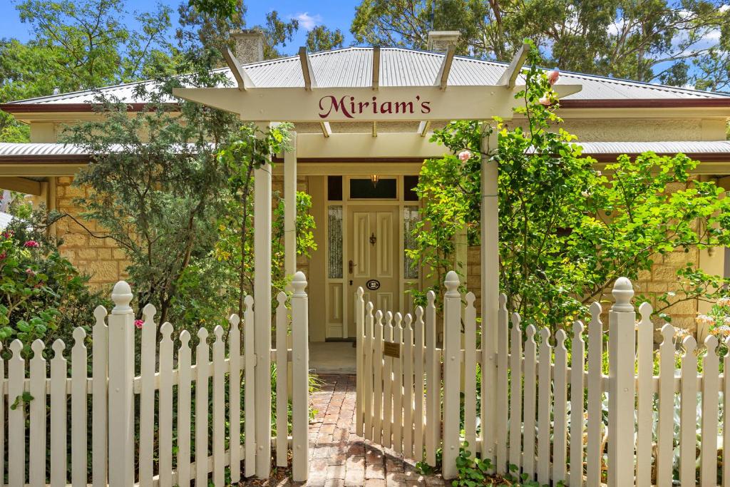 ein weißer Gartenzaun vor einem Haus in der Unterkunft Miriams Cottage in Tanunda