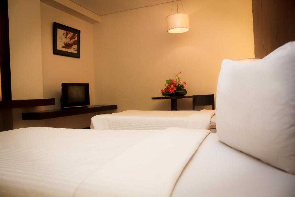 Postel nebo postele na pokoji v ubytování CityState Tower Hotel