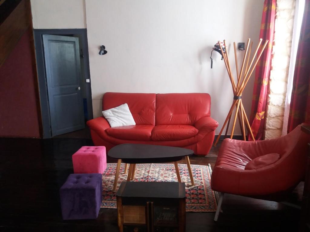 sala de estar con sofá rojo y silla en Au numéro 4, 