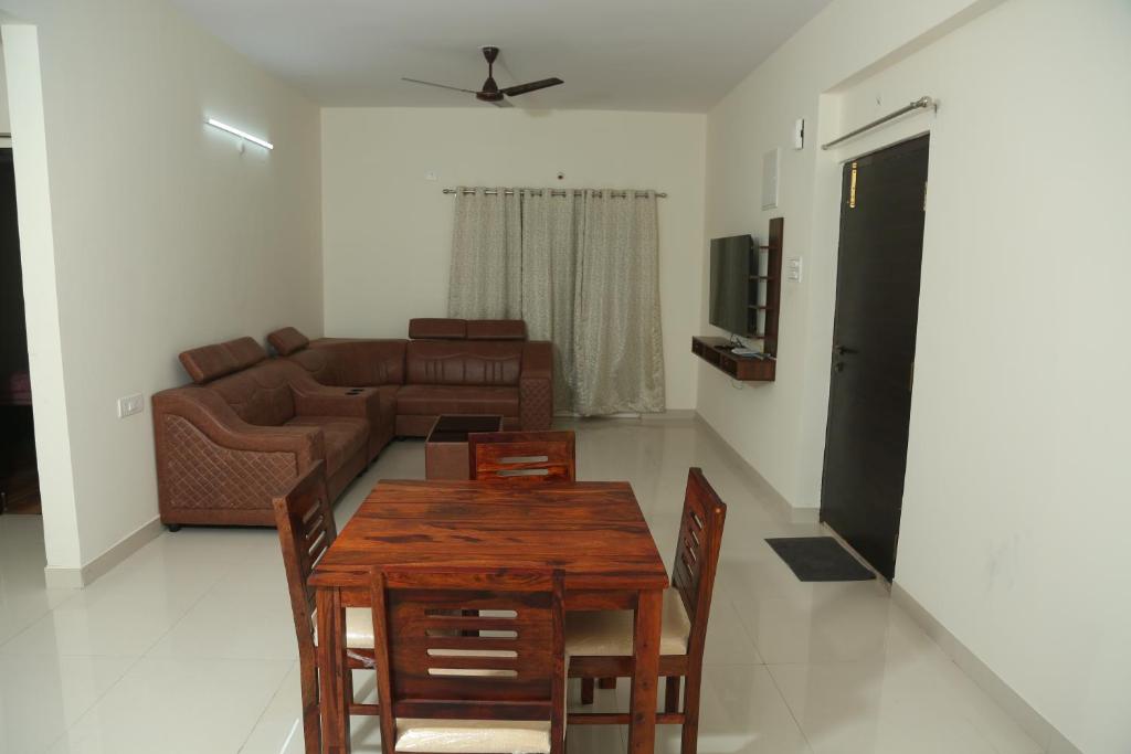 ein Wohnzimmer mit einem Holztisch und einem Sofa in der Unterkunft Mee Homes - Madhapur Fully Furnished 2 BHK Flats in Hyderabad