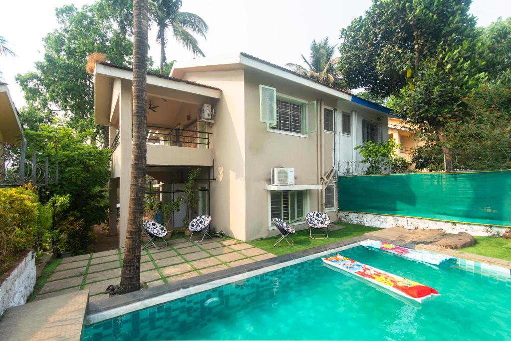 a house with a swimming pool in front of a house at SOUZAGAD VERDE in Panvel