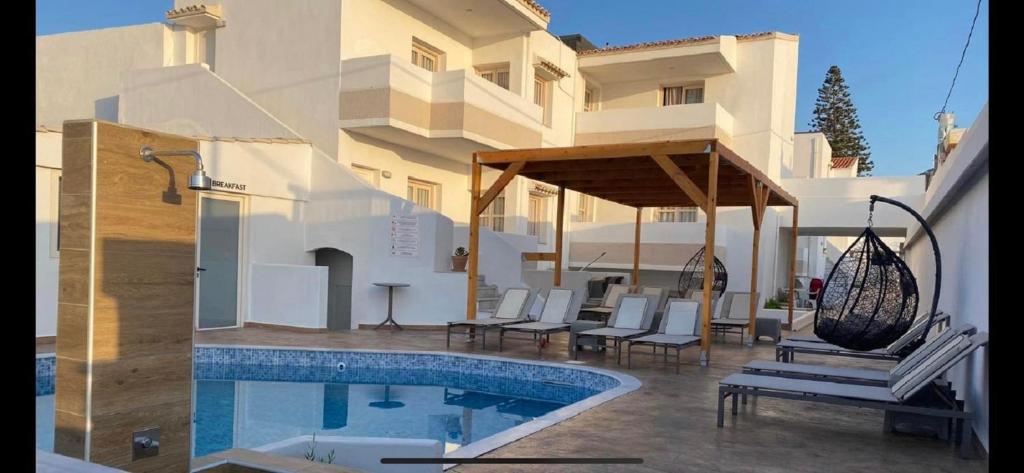 a house with a swimming pool next to a building at Coralli Beach Hotel in Kokkini Khanion