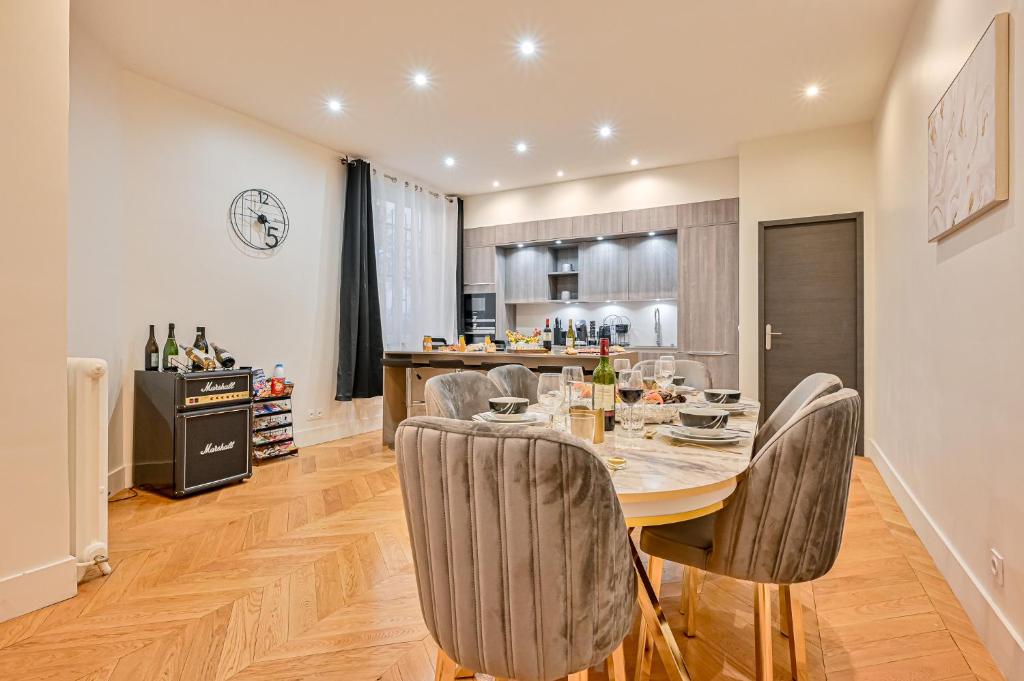 une cuisine et une salle à manger avec une table et des chaises dans l'établissement Magnifique Appartement de luxe & familia - Paris 16, à Paris