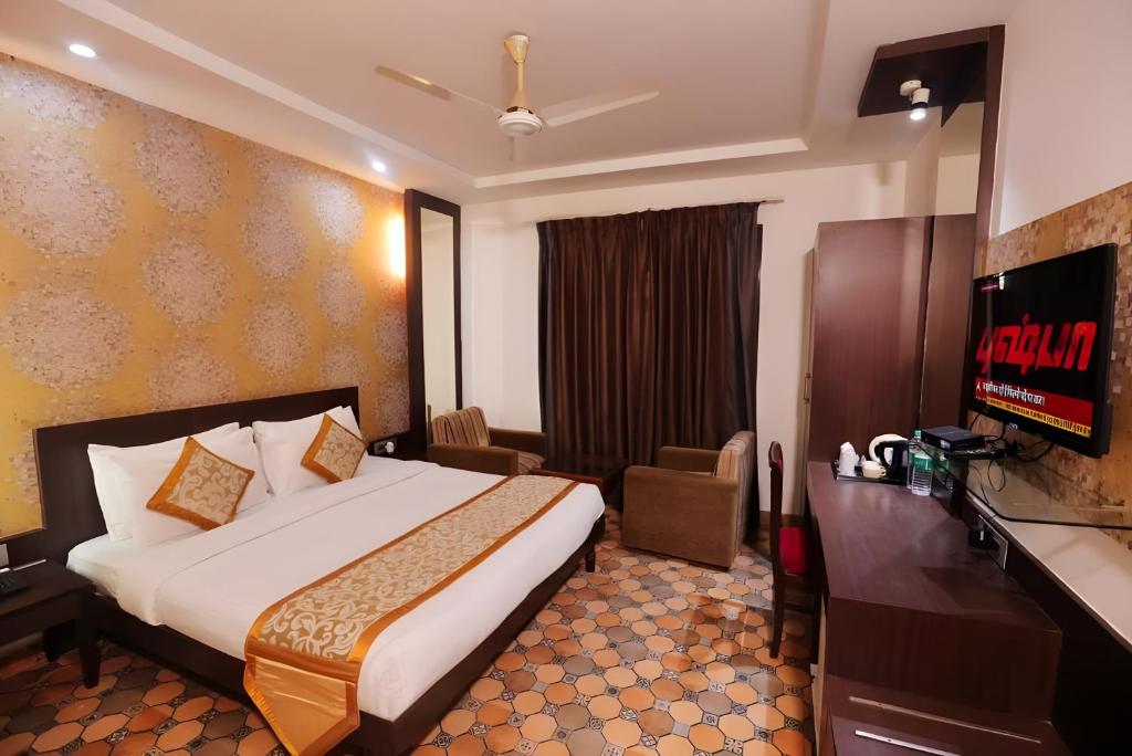 a hotel room with a bed and a flat screen tv at Hotel Panickers Residency - Ajmal Khan Market Karol Bagh in New Delhi