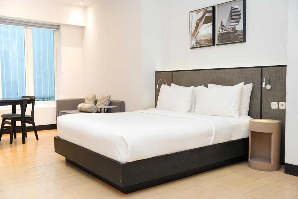a bedroom with a large bed and a desk at Lemansion Senopati in Jakarta