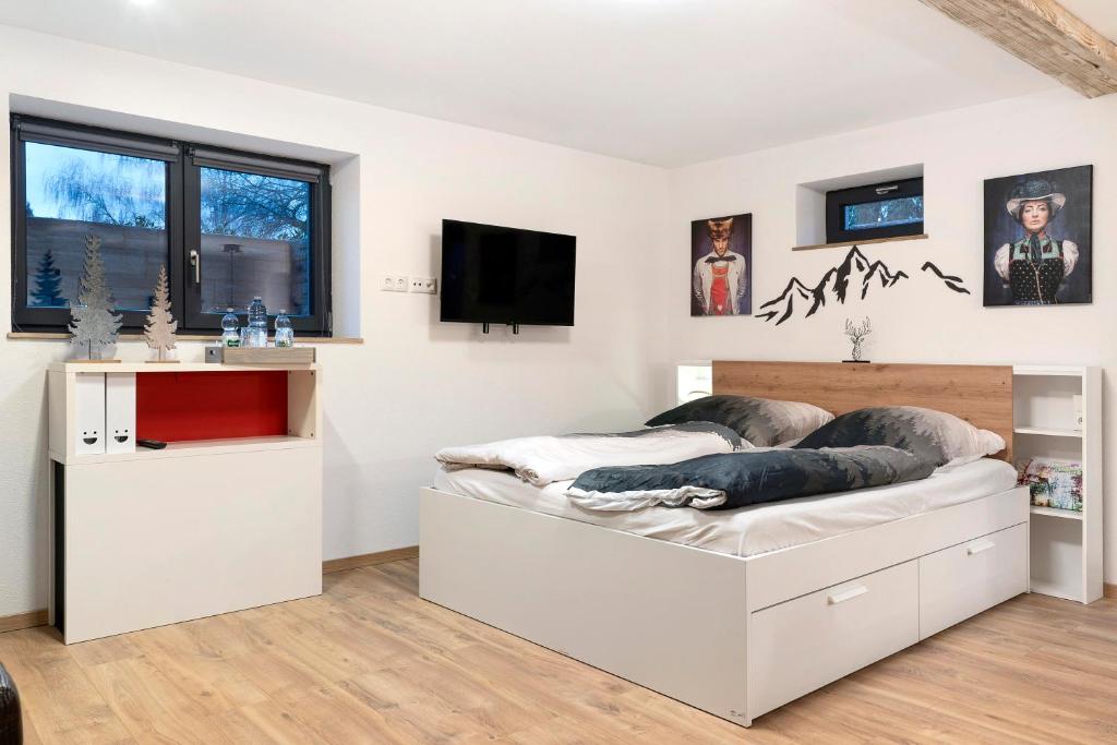 ein Schlafzimmer mit einem Bett und einem TV an der Wand in der Unterkunft Schwarzwald Chalet Achern in Achern