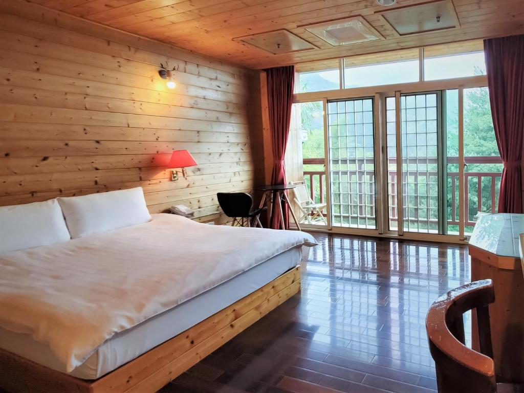a bedroom with a bed in a room with wooden walls at Kingtaiwan Hotel in Lugu Lake