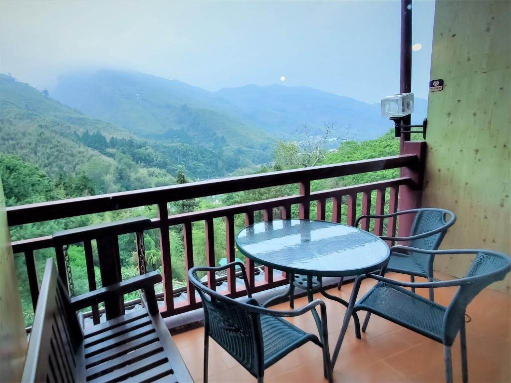 a table and chairs on a balcony with a view at Kingtaiwan Hotel in Lugu Lake