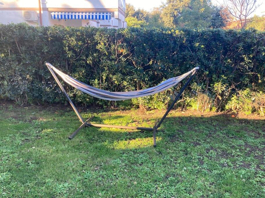 a hammock in the grass in front of a hedge at Oasi di serenità in Fregene
