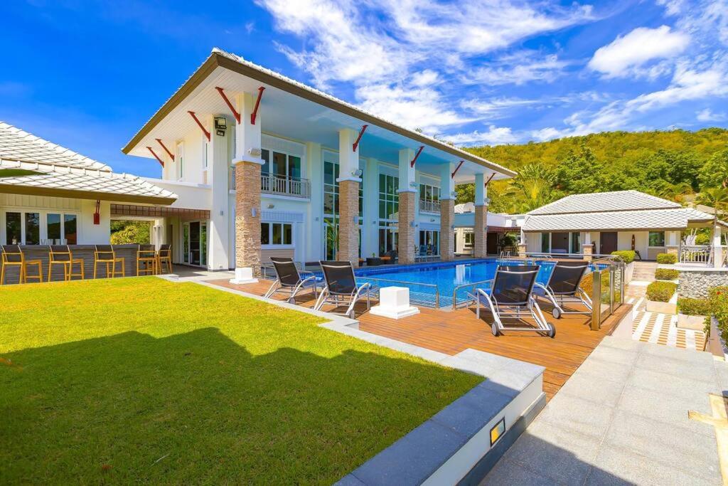 a house with a swimming pool and chairs at 7 Bedrooms Mansion on The Golf Course! JB2 in Hua Hin