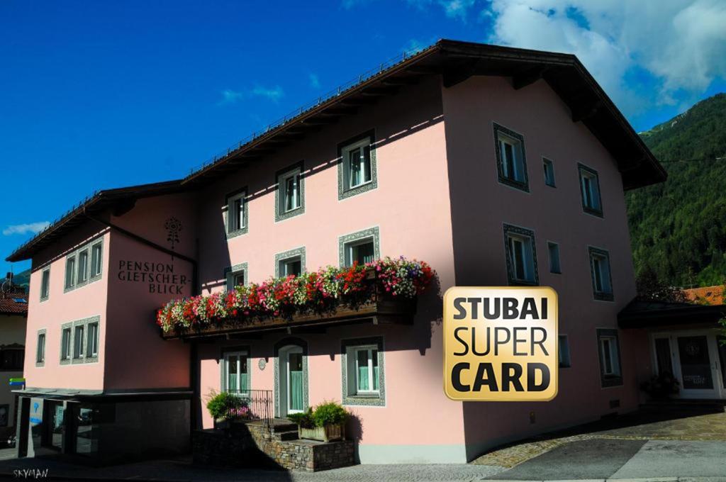 a building with a sign that reads surgical super card at Pension Gletscherblick in Fulpmes