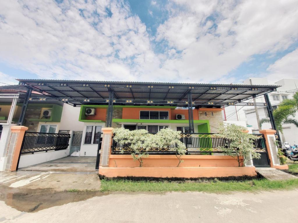 un bâtiment avec une pergola devant lui dans l'établissement Rumah Lavender near OPI Mall Jakabaring, à Palembang